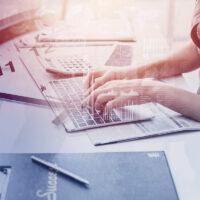 closeup hand business office woman typing on laptop computer overlay with times clock for working hours concept